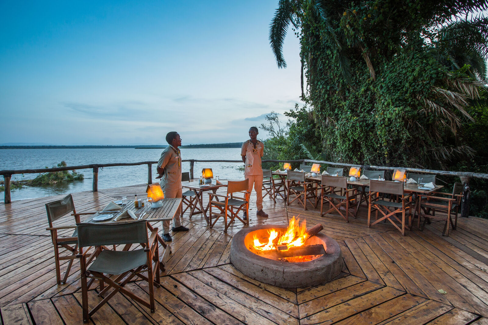 Two people at Ruzizi Lodge dining area overlooking the water